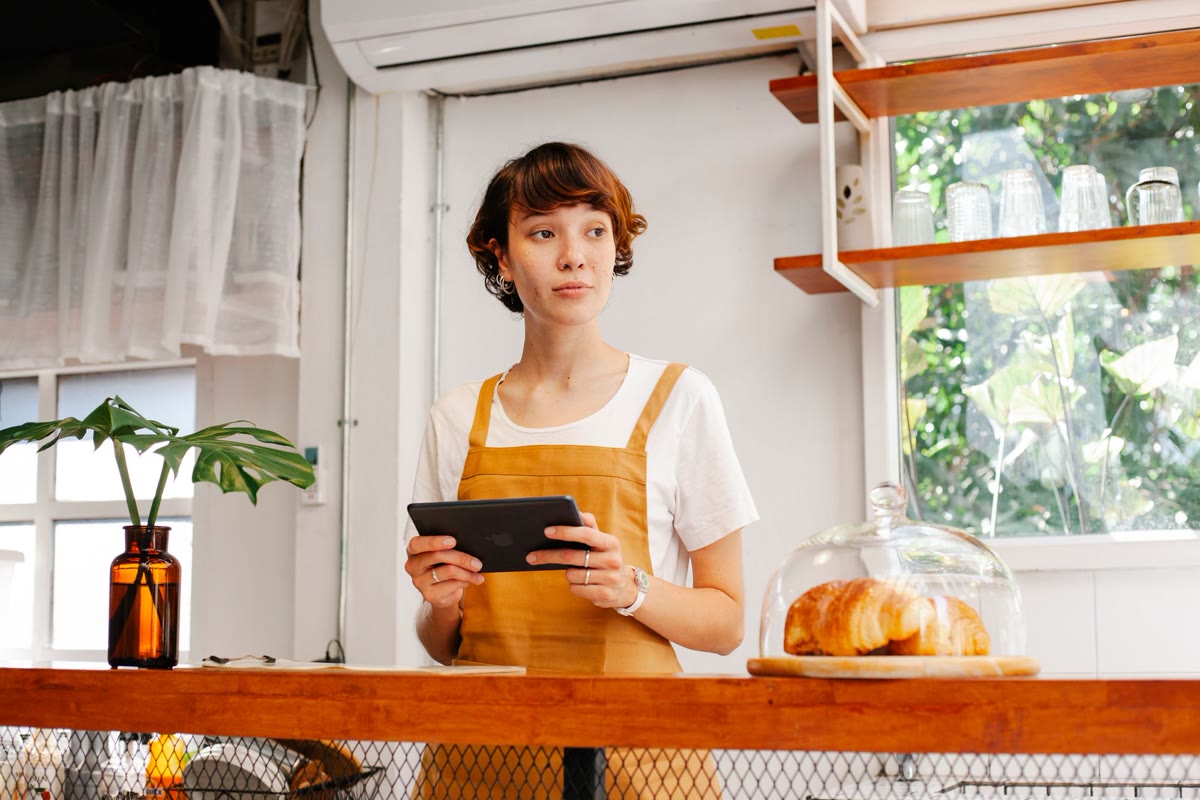 Marina Costa no balcão da lanchonete, com tablet na mão